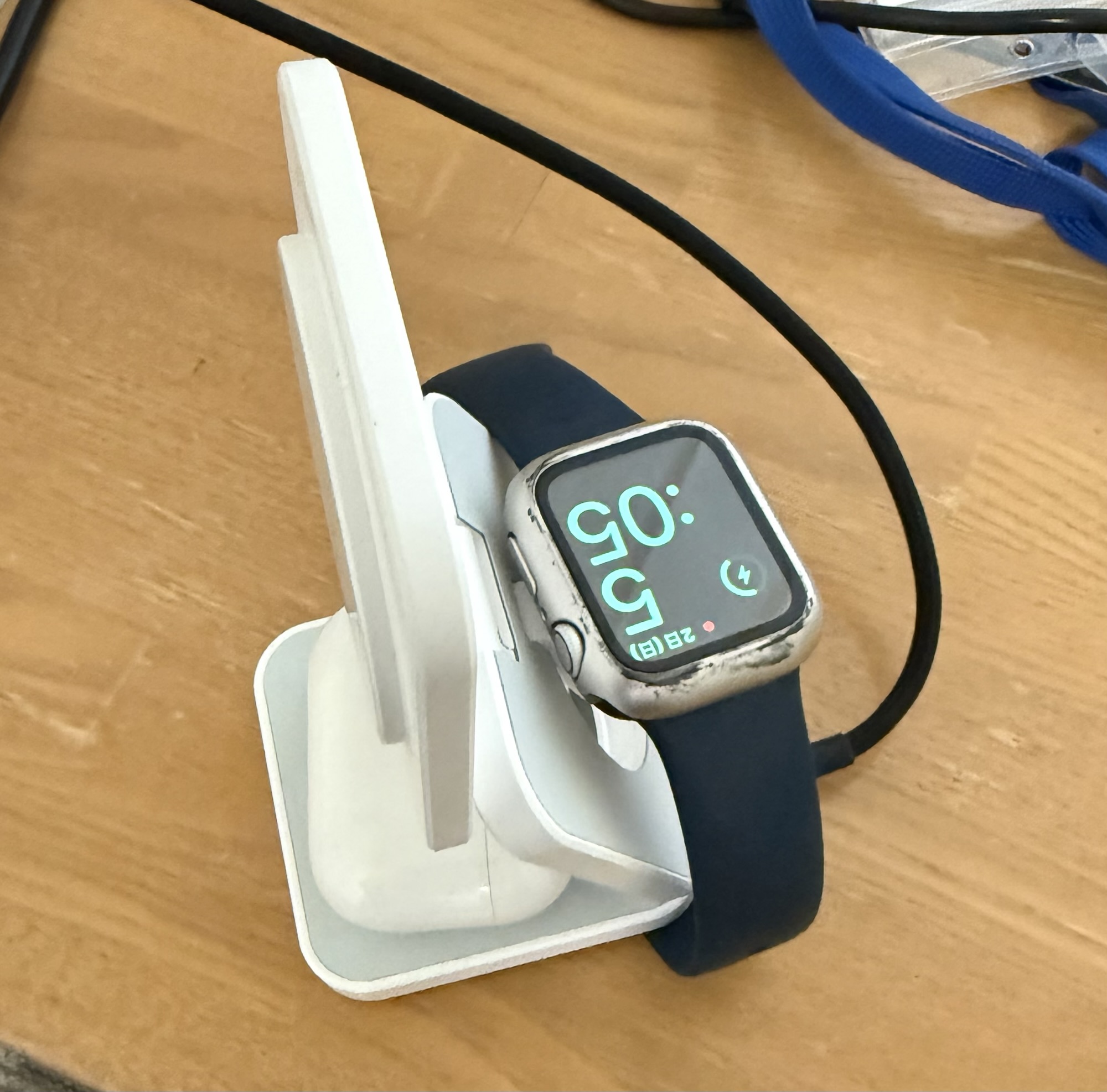 折りたたみ式3-in-1ワイヤレス充電器を広げてApple Watchを充電している様子。充電中のアイコンが表示されている